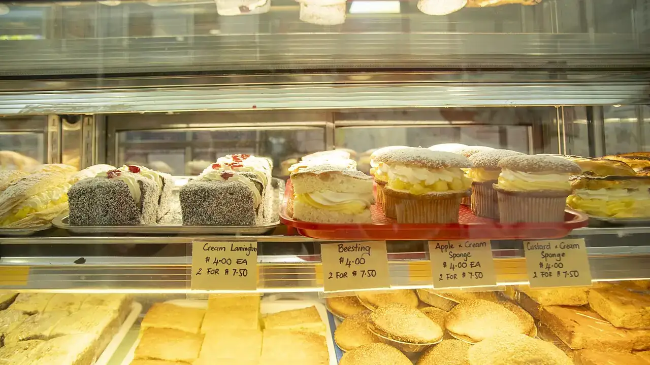 Lamingtons and cream buns in a cabinet